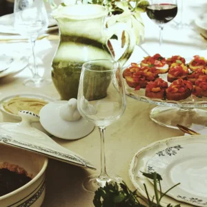 Photo détaillée d'une table avec de la nourriture, des verres et du vin.