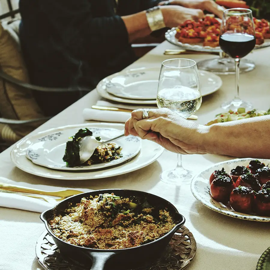 Picnic en Provence Ateliers A table filled with delicious food, people dining and glasses of wine.